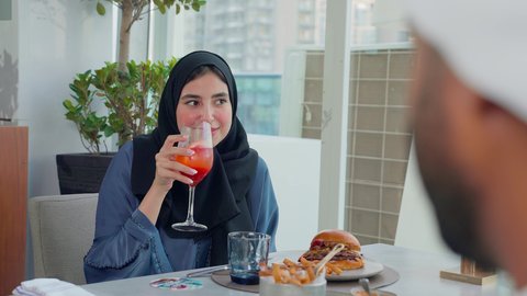 إيماءات السعادة والسرور، قضاء اوقات ممتعة مع الأصدقاء، تناول وجبة خفيفة, بناء وتعزيز العلاقات والصداقات، مناقشة الاعمال وتبادل الافكار، اجتماع عمل في مكان خارج مقر الشركة, تصوير مقرب لإمرأة عربية خليجية اماراتية يجلسون على طاولة في إحدى المطاعم في الإمارات