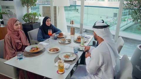 صورة للمحافظة على الذكريات، قضاء أوقات ممتعة مع الأصدقاء، طاوله مليئه بأصناف المأكولات والمشروبات، اجتماع عمل في مكان خارج مقر الشركة, مشاركة الأوقات الممتعة, تصوير مقرب لمجموعة من الأصدقاء العربيين الخليجيين الإماراتيين يجلسون على مائدة في إحدى المطاعم في الإمارات