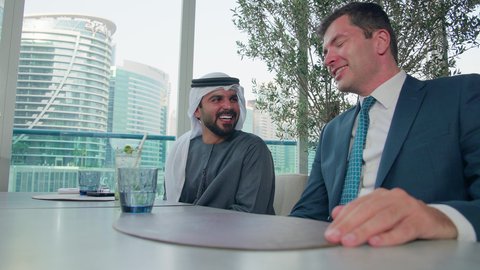 الكرم بين الاصدقاء في دفع الفاتورة, الدفع باستخدام الفيزا, اجتماع عمل في مكان خارج مقر الشركة, مشاركة الأوقات الممتعة, بناء علاقات اجتماعية ناجحة, مجموعة من الأصدقاء الاجانب والعرب خليجيين إماراتيين يجلسون على طاولة في إحدى المطاعم في الإمارات