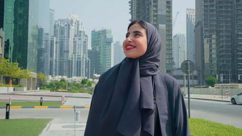 مشاهدة التطور العمراني في المدينة، النمو العمراني في الامارات ،استنشاق الهواء النقي ,  الفخر والاعتزاز بالتقدم المعماري ، امراه عربيه خليجيه اماراتيه ترتدي العباءه والحجاب تتجول فى الخارج