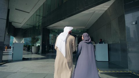 The joy of shopping with family, enjoying buying and shopping, acquiring necessities from malls, benefiting from offers, discounts, and seasonal sales, an Emirati Arab couple wandering in the mall, gestures of happiness and joy.