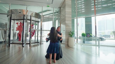 فتاة عربية خليجية اماراتيه تركض بتلهف لتعانق والدتها, مشاعر الأمومة و العطف، إقتناء المستلزمات من المولات،عناق وحب الأبناء، مفهوم الأسرة السعيدة ، قضاء أوقات عائلية ممتعة، الإستفادة من العروض والحسومات والتخفيضات الموسمية