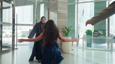 مشاعر الأمومة و العطف، إقتناء المستلزمات من المولات، فتاة عربية خليجية اماراتيه تركض بتلهف لتعانق والدتها, عناق وحب الأبناء، مفهوم الأسرة السعيدة ، قضاء أوقات عائلية ممتعة، الإستفادة من العروض والحسومات والتخفيضات الموسمية