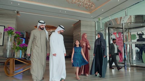 Acquiring necessities from malls, the joy of shopping with children and family, benefiting from offers, discounts, and seasonal sales, enjoying buying and shopping, a happy Emirati Gulf Arab family strolling in the mall, gestures of happiness and joy.