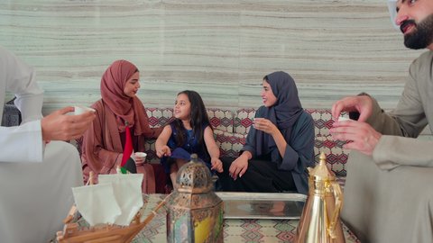 الاستمتاع بالمشروبات الساخنه ، كافيهات ومقاهي الامارات ،ايماءات البشاشة والترحيب بالضيوف ، مفهوم الضيافة والاستقبال ,مجموعة اصدقاء عرب خليجيون اماراتيون يجلسون فى مقهي يتبادلون الاحاديث، قضاء اوقات سعيده مع العائلة