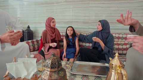 Cafes and coffee shops in the Emirates, enjoying hot drinks, cheerful gestures and welcoming guests, the concept of hospitality and reception, a group of Emirati Gulf Arab friends sitting in a cafe exchanging conversations, spending happy times with family