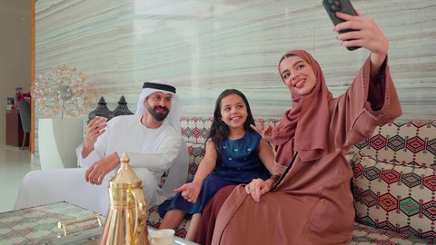 كافيهات ومقاهي الامارات،التقاط صور السيلفي باستخدام الجوال ، توثيق اللحظات التذكاريه ،الاستمتاع بالمشروبات الساخنه ، مفهوم الضيافة والاستقبال ,عائله عربيه خليجيه اماراتيه تجلس فى مقهي ، قضاء اوقات سعيده مع الاسره، ايماءات البشاشة والترحيب بالضيوف