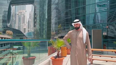 اجراء مكالمة هاتفية ، رجل عربي خليجي اماراتي يرتدي الكندورة والغتره يتجول حول المسبح في أحد الفنادق في المملكة العربية السعودية يستخدم الهاتف المحمول ،شاليهات و منتجعات فاخرة ،استخدام التقنيات الحديثة ، القيام بالأنشطة الترفيهية المسلية,  استنشاق الهواء النقي