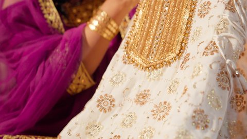 عادات وتقاليد الزواج في الامارات، تقديم الهدايا في المناسبات السعيدة، تصوير مقرب ليد العروس تحمل جلابية مطرزة ، الزي الشعبي التراثي التقليدي