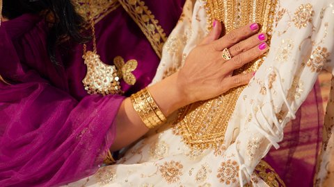 مراسم الزواج الخليجي الاماراتي، تقديم الهدايا في المناسبات السعيدة، تصوير مقرب ليد العروس تحمل جلابية مطرزة ، الزي الشعبي التراثي التقليدي