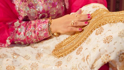 العادات الإماراتية في الزواج، تقديم الهدايا في المناسبات السعيدة، تصوير مقرب ليد ام العريس تحمل جلابية مطرزة ، الزي الشعبي التراثي التقليدي