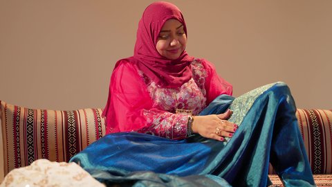 The Emirati customs in preparing gifts for the bride, the groom's mother wears a colored abaya and carries an embroidered jalabiya to present it as part of the wedding ceremonies, the traditional folk heritage attire.