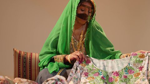 العادات والتقاليد الإماراتية في مراسم الزواج، تحضيرات ما قبل الزفاف لتقديم الهدايا, امراة عربيه خليجيه اماراتية تقوم بتحضير الجلابيات الاماراتية للعروس، الزي الشعبي التراثي التقليدي
