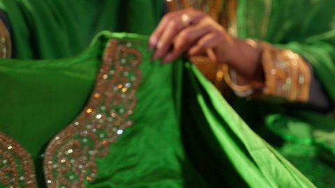 إعداد الهدايا وتغليفها لتقديمها في يوم الزفاف، العادات والتقاليد الإماراتية في مراسم الزواج, تصوير مقرب ليد امراة عربيه خليجيه اماراتية تقوم بتحضير الجلابيات الاماراتية للعروس، الزي الشعبي التراثي التقليدي