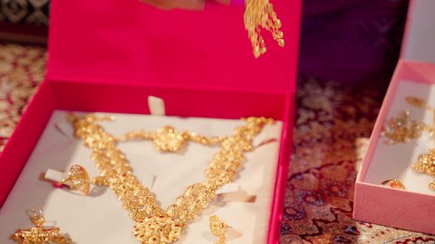 The Emirati customs in preparing the bride include elegance with sparkling accessories and gold jewelry, locally made Emirati gold. A close-up shot of the hand of an Emirati Gulf Arab bride wearing a gold ring on her finger.