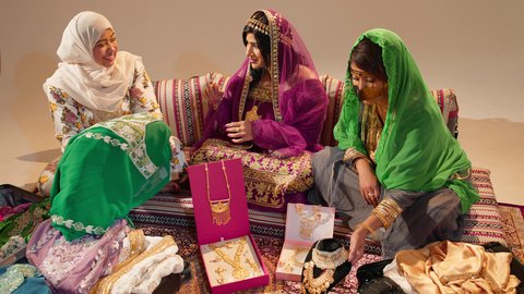 التحضيرات التقليدية للعروس الإماراتية، امراة عربيه خليجيه اماراتية برفقة ام العريس  يهدون العروس جلابية مطرزة فاخرة بمناسبة حفل زفافها، ايماءات السعادة و السرور