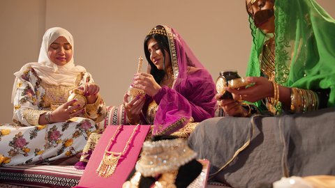 استعدادات العروس ليوم الزفاف، عادات متوارثة تعكس التراث والثقافة الاماراتية في المناسبات السعيدة، ام العريس ترتدي العباءة المطرزة  تمسك بعلبة بن تقدمها للعروس لتشم رائحتها، ايماءات السعادة و السرور