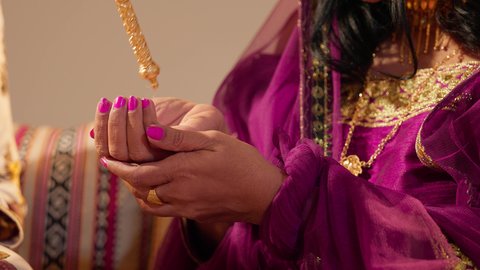 تحضيرات العروس الإماراتية قبل الزفاف، عادات متوارثة تعكس التراث والثقافة المحلية في المناسبات السعيدة، تصوير مقرب لعروس عربية خليجيه اماراتية ترتدي العباءة المطرزة تقوم بتعطير جسمها