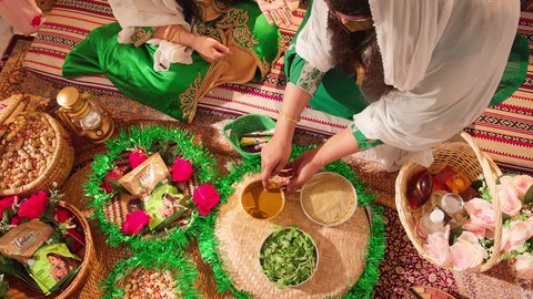 مهنة  تقليدية شعبية نسائية، فنون ونقوش وزخارف يدويه من مواد طبيعيه، التجمل والتزيين في يوم الزفاف، عادات وتقاليد في المناسبات والأفراح السعيدة، إمرأة عربية خليجية إماراتية تقوم بتحضير خلطة الحناء