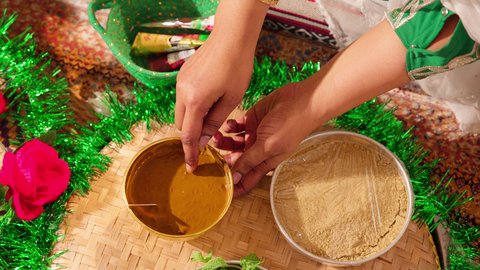 التجمل والتزيين في يوم الزفاف، مهنة  تقليدية شعبية نسائية، فنون ونقوش وزخارف يدويه من مواد طبيعيه، عادات وتقاليد في المناسبات والأفراح السعيدة، إمرأة عربية خليجية إماراتية تقوم بتحضير خلطة الحناء