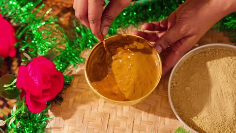 Beautification and adornment on the wedding day is a traditional popular women's profession, involving arts, designs, and handmade decorations from natural materials, customs and traditions in happy occasions and celebrations. An Arab Gulf Emirati woman prepares the henna mixture.