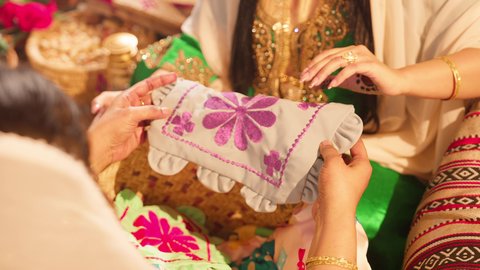 منتج محلي وطني ، تصوير مقرب ليد امراه عربية خليجية اماراتية تقوم بعرض قطعة قماش مطرز بالتطريز اليدوي الشعبي التقليدي , تراثيات وشعبيات اماراتيه تقليديه