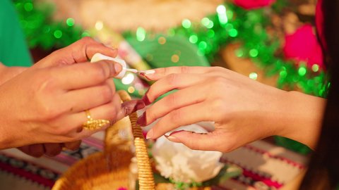 الاستعداد من اجل ليلة العمر، ازياء تقليدية شعبية نسائية، عادات وتقاليد في المناسبات والأفراح السعيدة، الاهتمام بالأناقة والمظهر الخارجي, امرأة عربية خليجية إماراتية محجبة ترتدي الزي الشعبي تقوم بوضع طلاء الأظافر للعروسة, شابة سعودية تقوم بالتزين والتجمل في يوم زفافها