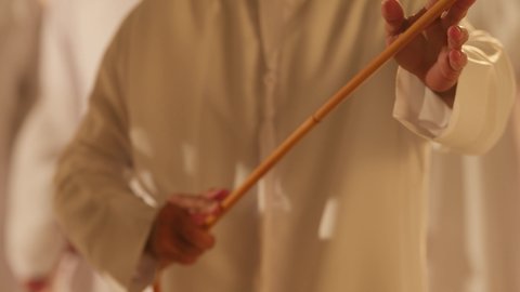 Harmony and coordination in dance movements during a national holiday, Al Ayala is a folk dance at festivals, interaction and dancing with the khazaan, a traditional celebration and national occasion, the heritage folklore troupe, celebrating the national day, a close-up shot of an Arab Gulf Emirati man wearing traditional attire dancing with a team.