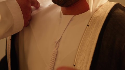 تقديم العون لعريس يلبس البشت الاماراتي، شباب يحتفلون بصديقهم في زفافه، فرقة العرضة العيالة،  فن ادائي يجمع بين الرقص، الاحتفالات في الزفاف الاماراتي، عروض مسرحيه شعبيه، رقصات شعبيه في زفاف والمناسبات، تصوير مقرب لاحياء اجواء رائعة  لعريس اماراتي خليجي عربي