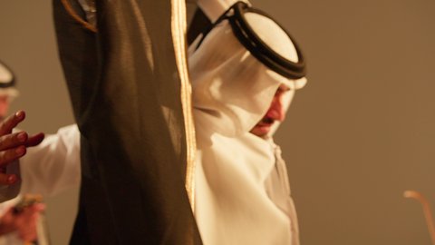 مساعدة العريس بلبس البشت الاماراتي، شباب يحتفلون بصديقهم في زفافه، فرقة العرضة العيالة،  فن ادائي يجمع بين الرقص، الاحتفالات في الزفاف الاماراتي، عروض مسرحيه شعبيه، رقصات شعبيه في زفاف والمناسبات الوطنية، تصوير مقرب لاحياء اجواء رائعة  لعريس اماراتي خليجي عربي