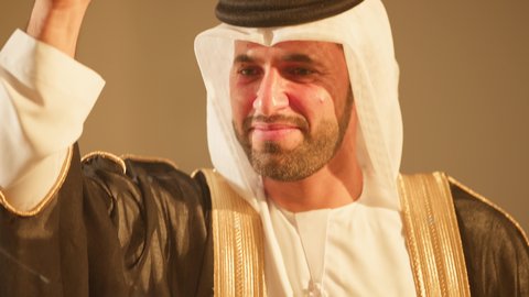 الاحتفالات في الزفاف الاماراتي، التفاعل والتناغم في رقصة شعبيه في زفاف ، شاب يرقص باستخدام الخيرزان العيالة، الاستعاد والتهيء لدخول الزفاف، إظهار الولاء والحب للوطن،  فن ادائي يجمع بين الرقص، عروض مسرحيه شعبيه، تصوير لاجواء رائعة  لعريس اماراتي خليجي عربي