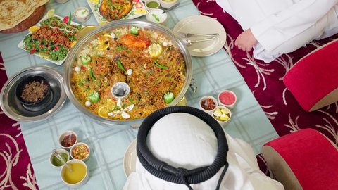 Delicious Eastern dishes, popular Arab Gulf Emirati cuisine, a close-up shot of the hand of an Arab Gulf Emirati man eating fresh meat in a restaurant.