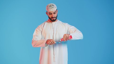 روتين نظافة الفم اليومية ،بورتريه لرجل عربي خليجي اماراتي  يقوم بتنظيف الأسنان بفرشاة الأسنان ، مفهوم العناية والإهتمام بصحة ونظافة الأسنان ، تجنب تسوس الاسنان وامراض اللثة ، خلفية ملونة