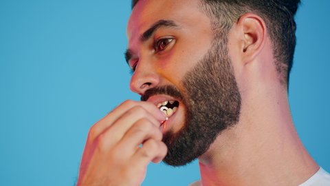 بورتريه لرجل  عربي خليجي اماراتي يرتدي الزي التقليدي الاماراتي تقوم بإستخدام خيط تنظيف الأسنان ، مفهوم العناية والإهتمام بصحة الأسنان ، معدات طب الأسنان ، نظافة الأسنان يوميا ، خلفية ملونه