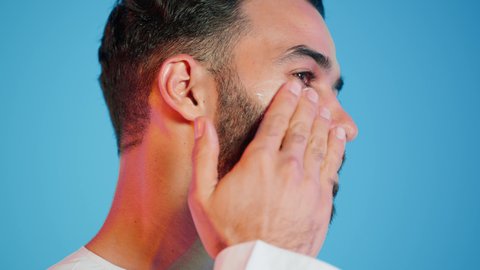 مقهوم العنايه اليوميه ، استخدام مكونات تجميلية شبابية، الإهتمام بنضارة وتحسين البشرة، ترطيب وتنظيف وتفتيح الجلد، بورتريه لرجل عربي خليجي اماراتي  يرتدي االزي  التقليدي يمسك بيده كريم المرطب ويضعه على الوجه، خلفية ملونه