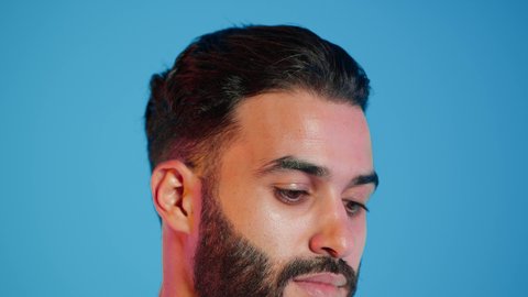 استخدام مكونات تجميلية شبابية، مفهوم العناية والإهتمام بنضارة وتحسين البشرة، ترطيب وتنظيف وتفتيح الجلد، بورتريه لرجل عربي خليجي اماراتي  يرتدي االزي  التقليدي يمسك بيده كريم المرطب ويضعه على الوجه، خلفية ملونه