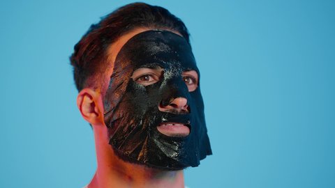 استخدام مكونات تجميلية، خطوات تنظيف وتقشير البشرة، بورتريه لرجل عربي خليجي اماراتي يرتدي الزي التقليدي يقوم بوضع قناع الطين على وجهه، مفهوم العناية والاهتمام بالمظهر الخارجي، خلفية ملونة.