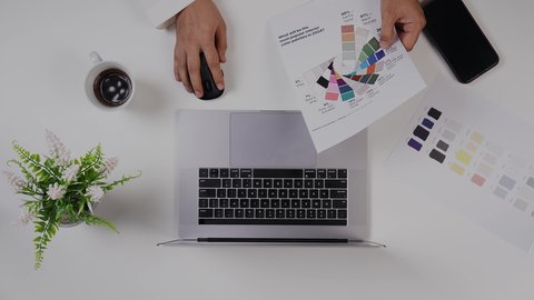 استخدام التقنيات الحديثة ، مصمم خليجي يعمل من خلال اللابتوب على مكتب أبيض, وظيفة ومهن سعودية, تصوير مقرب من الأعلى لرجل سعودي عربي لديه خبره بدرجات الألوان ,بيئة عمل  مكتبية, خلفية بيضاء .