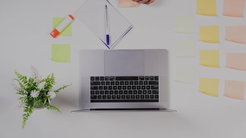 بيئة عمل مكتبية ,تصوير مقرب من الأعلى  ليد ولد سعودي عربي يعمل من خلال اللابتوب على مكتب أبيض , مهن ووظيفة سعودية ,  خلفية بيضاء .