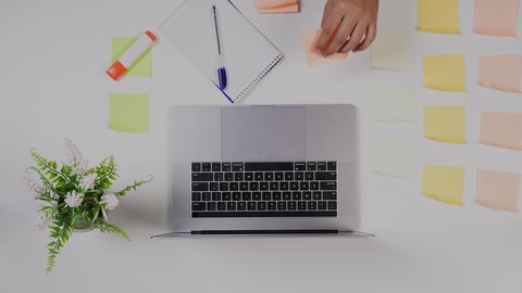 استخدام التقنيات الحديثة ، تصوير مقرب من الأعلى  ليد ولد سعودي عربي يعمل من خلال اللابتوب على مكتب أبيض , مهن ووظيفة سعودية , بيئة عمل مكتبية , خلفية بيضاء .