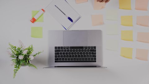 مهن ووظيفة سعودية ,تصوير مقرب من الأعلى  ليد ولد سعودي عربي يعمل من خلال اللابتوب على مكتب أبيض , بيئة عمل مكتبية , خلفية بيضاء .