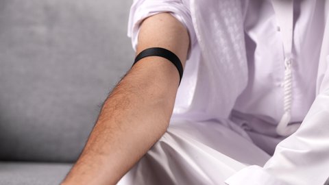 إدخال المخدرات مباشرة إلى الدم عبر الحقن الوريدي، المعاناة من الاضطرابات النفسية والمشاكل الصحية، الآثار السلبية للادمان، القيام بعادات سلوكية ضارة وتعاطي المواد السامة، تصوير مقرب لرجل عربي خليجي إماراتي يرتدي الكندورة يقوم بأخذ جرعة مخدرة