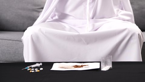 المعاناة من آلام الرأس، تصوير مقرب لرجل عربي خليجي إماراتي يرتدي الكندورة والغترة يضع يده على رأسه بإيماءات التعب والإرهاق، تعابير الضجر والاكتئاب عند إيقاف التدخين، الأعراض الجانبية لسحب المواد المخدرة من الجسم