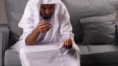 معاقبة النفس وتأنيب الضمير، الادمان على التبغ والمخدرات، المعاناة من الاضطرابات النفسية والمشاكل الصحية، رجل عربي خليجي إماراتي يرتدي الكندورة يمسك بيده سيجارة حشيش، عادات سلوكية ضارة وتعاطي مواد سامة
