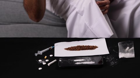 التعرض لفقدان الوعي نتيجة التعاطي، اتباع عادات سلوكية خاطئة، تصوير مقرب لايدي رجل عربي خليجي إماراتي يرتدي الكندورة يتعاطى جرعة كبيرة من المخدرات، المعاناة من الاضطرابات الجسدية والنفسية بسبب الإدمان