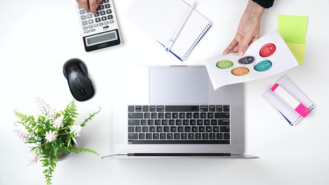 بيئة عمل مكتبية, تصوير مقرب من الأعلى لامراة عربية سعودية لديها خبره بالمحاسبة تعمل من خلال اللابتوب على مكتب أبيض , وظيفه ومهن سعودية , خلفية بيضاء .