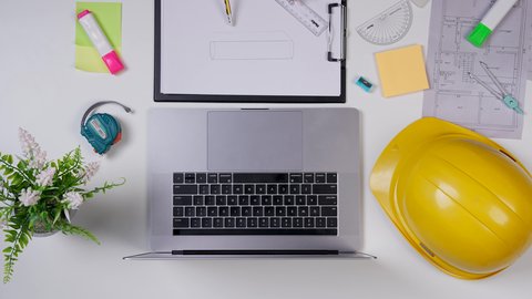 Saudi jobs and professions, taking important notes, an engineer working on designing buildings using a laptop on a white desk, a close-up shot from above of a Gulf female architect, office work environment, white background.