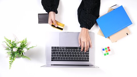 الشراء والدفع عن طريق بطاقة الإئتمان البنكية, إمكانية تسديد الفواتير ببطاقة الصراف, تصوير مقرب من الاعلى ليد امراة عربيه خليجيه سعودية تستخد الحاسب المحمول