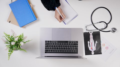 مفهوم الرعاية الصحية, دمج التكنولوجيا بالطب ، القطاع الطبي بالمملكة العربية السعودية, تصوير مقرب من الأعلى لطبيبة خليجية سعودية تعمل على الحاسوب المحمول في العيادة, تقديم الاستشارات الطبية