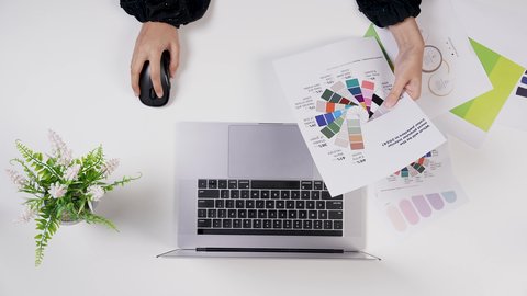 تنفيذ مهام التصميم عبر الحاسوب المحمول, استخدام التقنيات الحديثة ، مصممة خليجية تعمل من خلال اللابتوب على مكتب أبيض, وظيفة ومهن سعودية, تصوير مقرب من الأعلى لامراة سعودية عربية خليجيه لديها خبره بدرجات الألوان ,بيئة عمل مكتبية, خلفية بيضاء